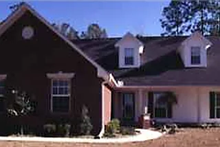 Deep red brick home with a steep front gable and white dormers