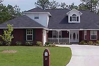 Brick home with dormers, a bonus room over the garage and a front porch