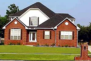 Two-story red brick home with a white gable and arched window