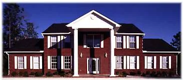 Gamble Construction’s two-story red brick office with white columns on Ferdon Boulevard